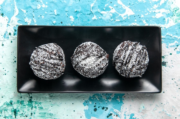 Vue de dessus de délicieuses boules de chocolat gâteaux au chocolat avec glaçage sur la surface bleue