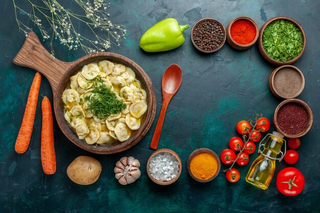 Vue de dessus de délicieuses boulettes avec différents assaisonnements sur mur vert foncé ingrédient alimentaire produit pâte viande légume