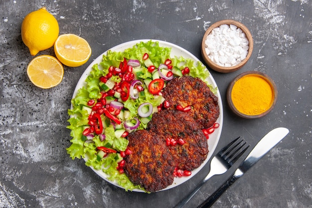 Vue de dessus de délicieuses côtelettes frites avec salade fraîche