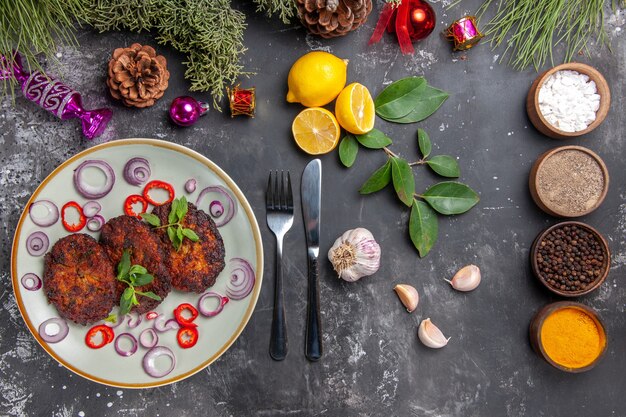 Vue de dessus de délicieuses côtelettes avec des rondelles d'oignon sur fond gris plat viande cuisine