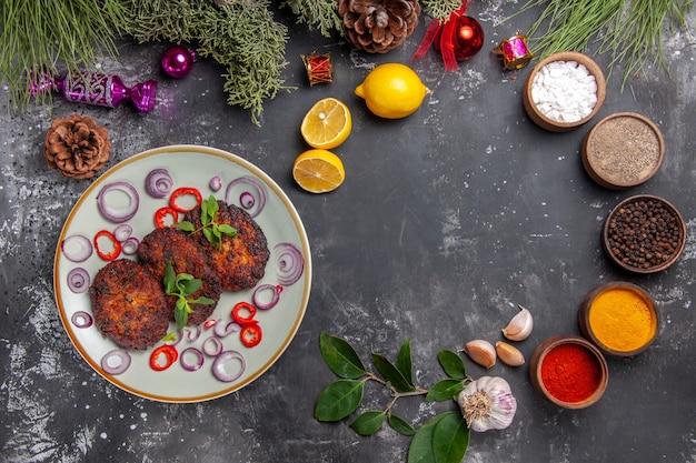 Vue de dessus de délicieuses côtelettes avec des rondelles d'oignon sur le fond gris repas photo plat viande