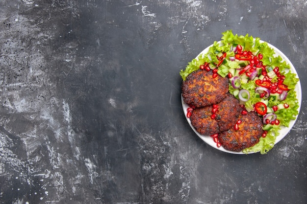 Vue de dessus de délicieuses côtelettes de viande avec salade fraîche