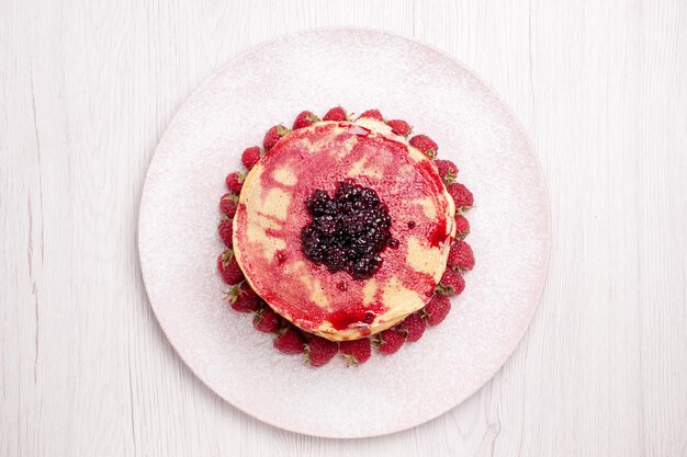 Vue de dessus de délicieuses crêpes aux fraises et à la gelée sur fond blanc tarte aux fruits gâteau biscuit baies sucrées