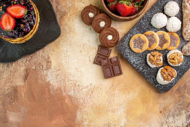 Vue de dessus de délicieuses crêpes avec des bonbons et des biscuits sur une surface en bois
