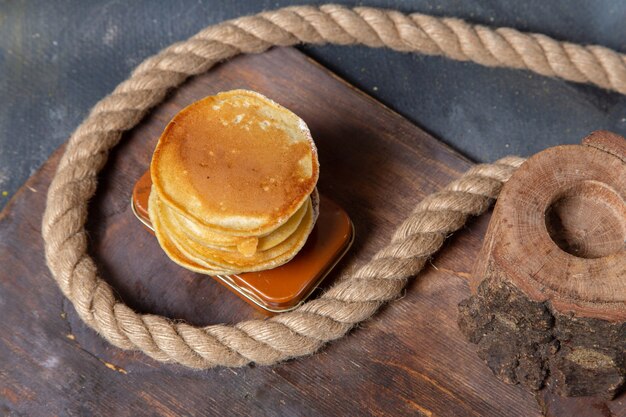 Vue de dessus de délicieuses crêpes avec des cordes sur le petit-déjeuner repas sucré fond gris