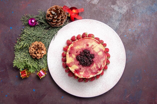 Vue de dessus de délicieuses crêpes fruitées avec une tasse de thé dans l'obscurité