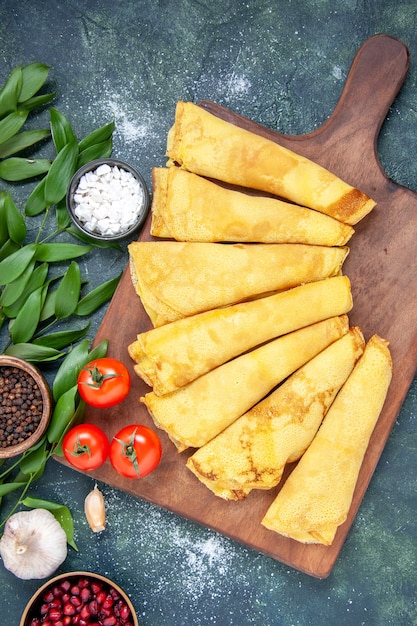 Vue de dessus de délicieuses crêpes roulées sur fond sombre tarte à la pâte à gâteau couleur de la viande pâtisserie gâteau sucré repas