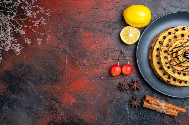 Vue de dessus de délicieuses crêpes sucrées au citron sur une surface sombre