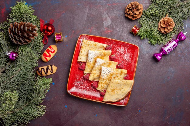 Vue de dessus de délicieuses crêpes sucrées aux framboises sur fond noir