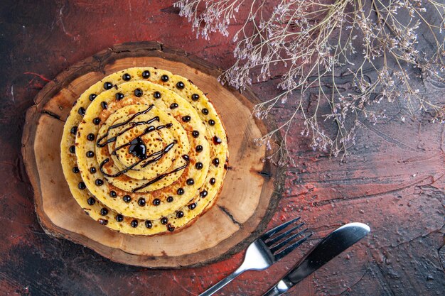 Vue de dessus de délicieuses crêpes sucrées avec du glaçage sur la surface sombre