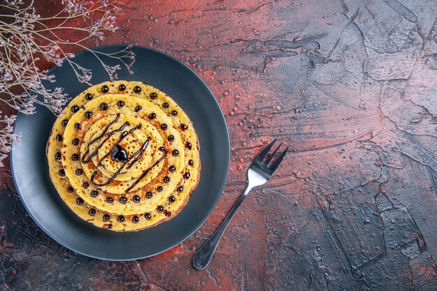 Vue de dessus de délicieuses crêpes sucrées avec du glaçage sur une surface sombre