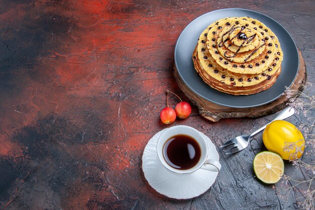 Vue de dessus de délicieuses crêpes sucrées avec glaçage au chocolat sur une surface sombre