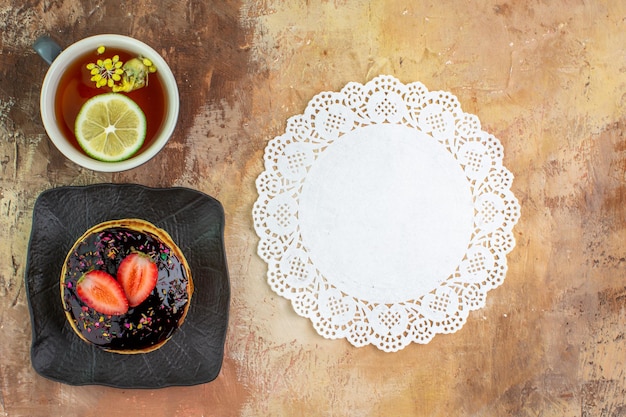 Photo gratuite vue de dessus de délicieuses crêpes sucrées avec une tasse de thé sur un bureau léger