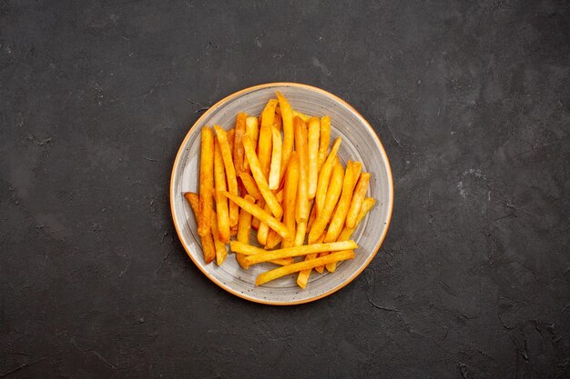 Vue de dessus de délicieuses frites à l'intérieur de la plaque sur fond sombre burger de pommes de terre repas sandwich dîner plat