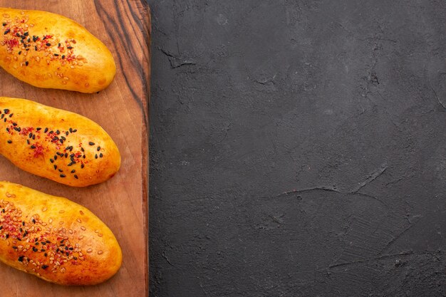 Vue de dessus de délicieuses galettes fraîchement sorties du four sur fond gris foncé pâte à tarte pâtisserie au four à la viande gâteau cuire