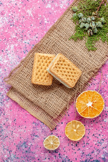 Vue de dessus de délicieuses gaufres au citron sur un bureau rose