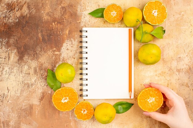 Vue de dessus de délicieuses mandarines fraîches avec bloc-notes