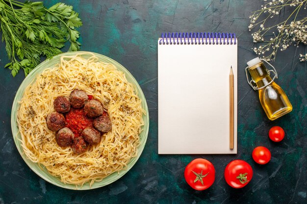 Vue de dessus de délicieuses pâtes italiennes avec des boulettes de viande et sauce tomate sur le fond bleu foncé pâte plat de pâtes viande dîner alimentaire italie