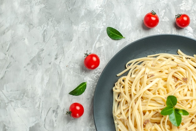 Vue de dessus de délicieuses pâtes italiennes avec des couverts sur fond clair