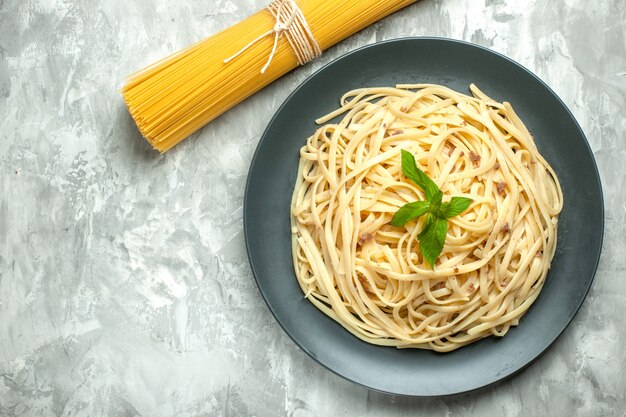 Vue de dessus de délicieuses pâtes italiennes avec des pâtes crues sur fond blanc