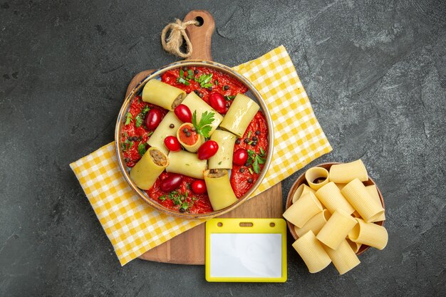 Vue de dessus de délicieuses pâtes italiennes avec de la viande et de la sauce tomate sur un mur gris foncé repas pâtes alimentaires pâte à dîner