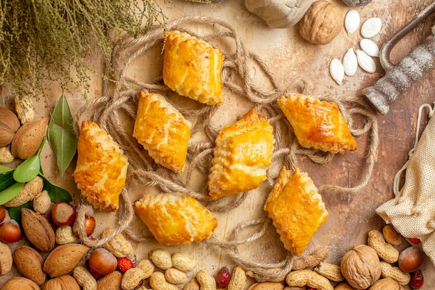 Vue de dessus de délicieuses pâtisseries aux noix avec des noix fraîches sur le bureau brun