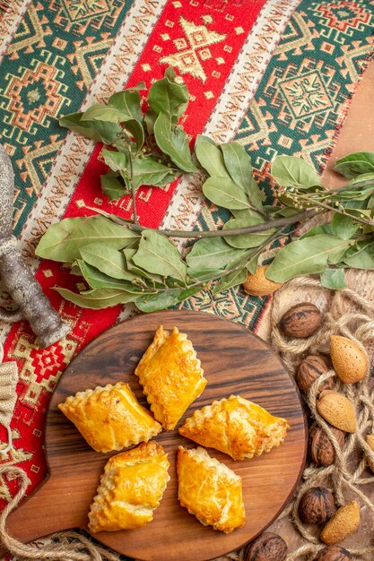 Vue de dessus de délicieuses pâtisseries aux noix avec des noix fraîches sur le bureau brun