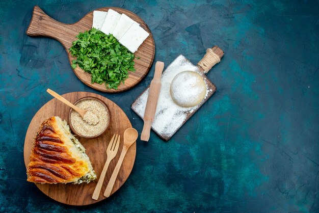 Vue de dessus de délicieuses pâtisseries cuites au four tranchées avec des verts à l'intérieur avec du fromage blanc et des verts sur le fond sombre.