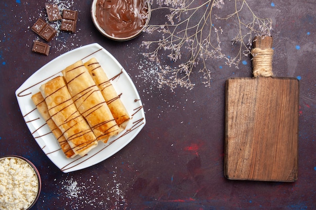 Vue de dessus de délicieuses pâtisseries sucrées au chocolat sur l'espace violet foncé