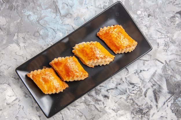 Vue de dessus de délicieuses pâtisseries sucrées à l'intérieur d'un moule à gâteau sur un gâteau à tarte blanc sucré