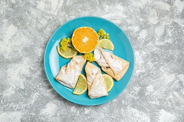 Vue De Dessus De Délicieuses Pâtisseries Avec Des Tranches De Citron Sur Une Surface Blanche