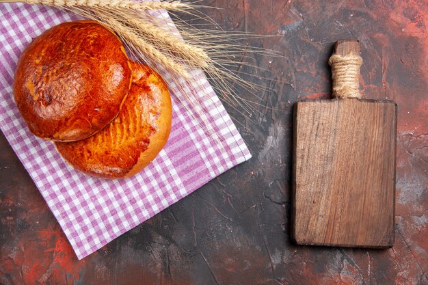 Vue de dessus de délicieuses tartes sucrées sur tarte de bureau sombre biscuit pâtisserie gâteau sucré