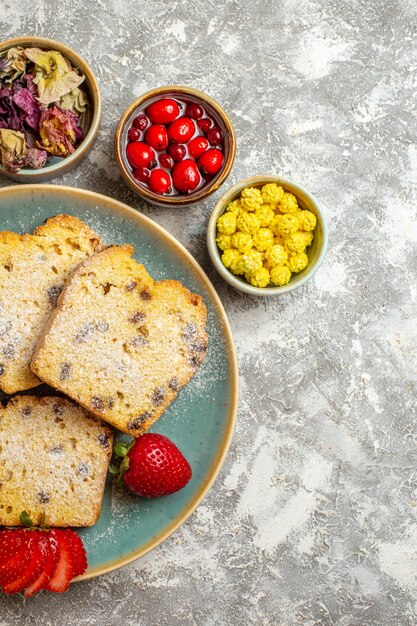 Vue de dessus de délicieuses tranches de gâteau aux fruits sur une surface légère gâteau aux fruits tarte sucrée