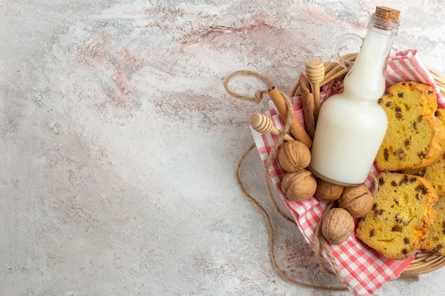 Vue de dessus de délicieuses tranches de gâteau avec du lait et des noix sur le fond blanc