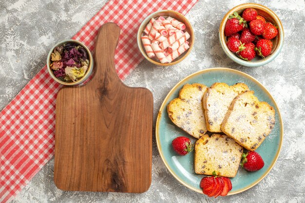 Vue de dessus de délicieuses tranches de gâteau avec des fraises fraîches sur blanc