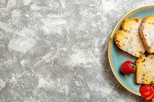 Vue de dessus de délicieuses tranches de gâteau avec des fruits sur des bonbons de tarte aux fruits de surface légère