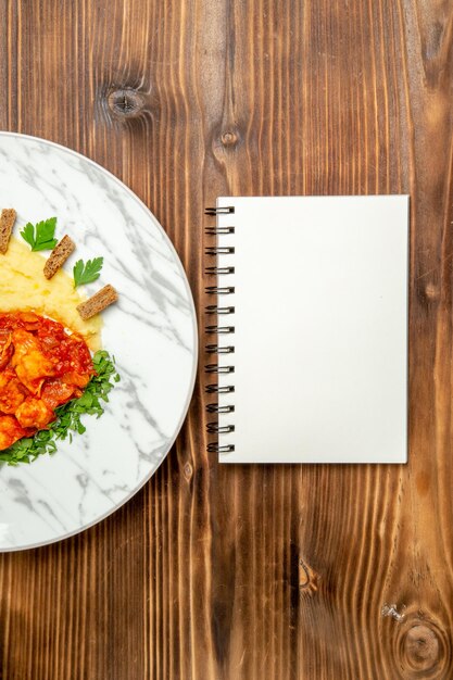 Vue de dessus de délicieuses tranches de poulet avec purée de pommes de terre sur une table brune.