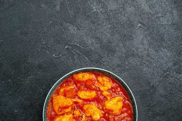 Vue de dessus de délicieuses tranches de poulet à la sauce tomate sur un plat de sauce de bureau gris viande poulet tomate