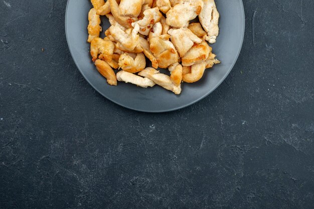 Vue de dessus de délicieuses tranches de poulet sur une surface sombre