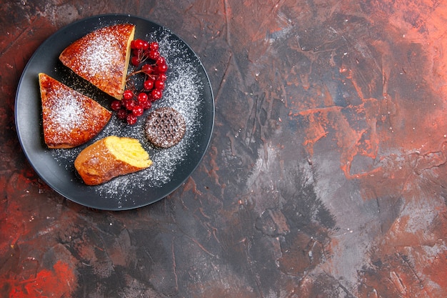 Vue de dessus de délicieuses tranches de tarte aux fruits rouges sur le gâteau de tarte sucrée de table sombre