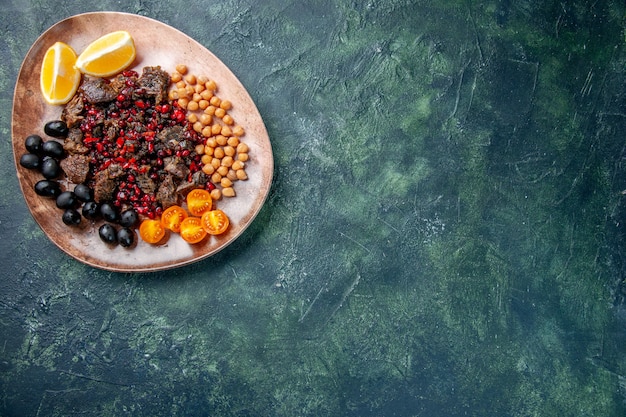 Vue de dessus de délicieuses tranches de viande frites avec des raisins de haricots et des tranches de citron à l'intérieur de la plaque, plat repas nourriture fruits viande