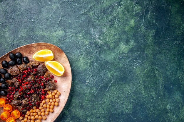 Vue de dessus de délicieuses tranches de viande frites avec des raisins de haricots et des tranches de citron à l'intérieur de la plaque, viande de fruits de nourriture