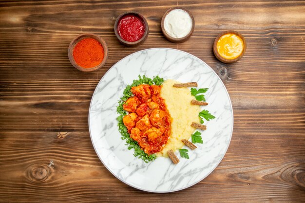 Vue de dessus de délicieuses tranches de viande avec purée de pommes de terre et assaisonnements sur un bureau en bois pain de viande repas de pommes de terre plat de nourriture