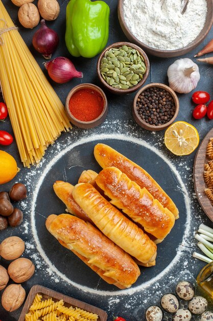 Vue de dessus délicieux bagels aux noix oeufs pâtes et assaisonnements sur le fond sombre noix poivre photo couleur nourriture fruits pâtisserie repas sucré