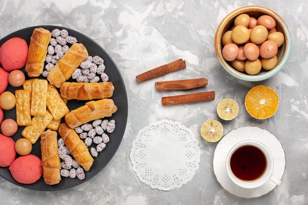 Vue de dessus de délicieux bagels avec des craquelins à la cannelle et des biscuits sur un biscuit de gâteau de bureau blanc léger