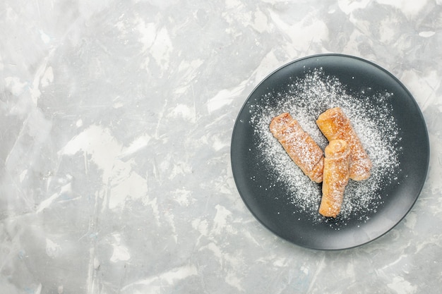 Vue de dessus de délicieux bagels sucrés en poudre sur une surface blanche