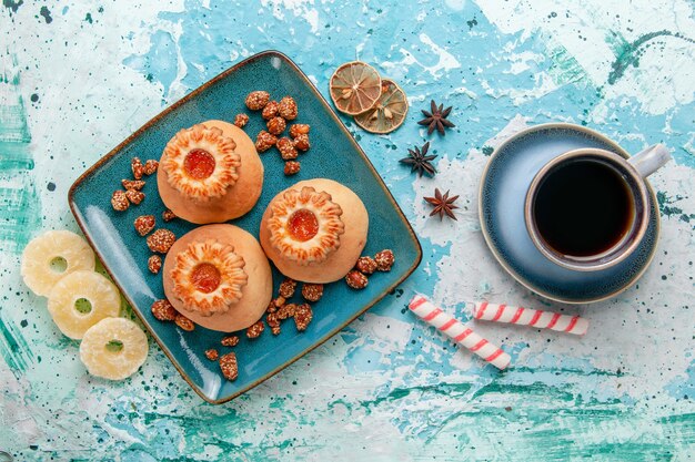 Vue de dessus de délicieux biscuits avec des anneaux d'ananas séchés sur la surface bleu clair biscuit biscuit couleur sucre sucré