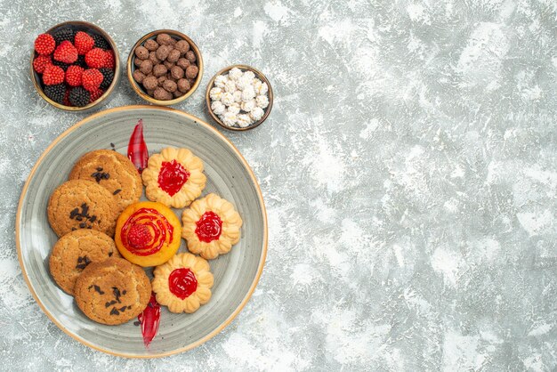 Vue de dessus de délicieux biscuits au sable avec des biscuits et des bonbons sur fond blanc biscuit au sucre gâteau biscuit thé sucré