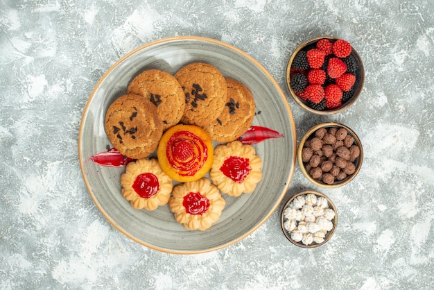 Vue de dessus de délicieux biscuits au sable avec des biscuits et des bonbons sur fond blanc biscuit au sucre gâteau biscuits thé sucré