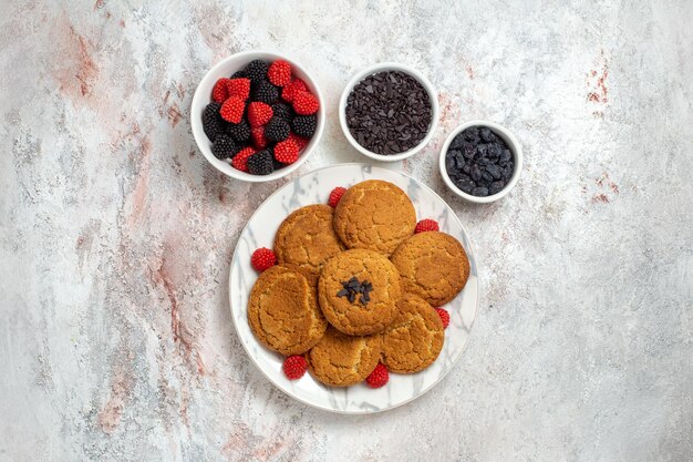 Vue de dessus de délicieux biscuits au sucre avec des confitures de baies sur une surface blanche